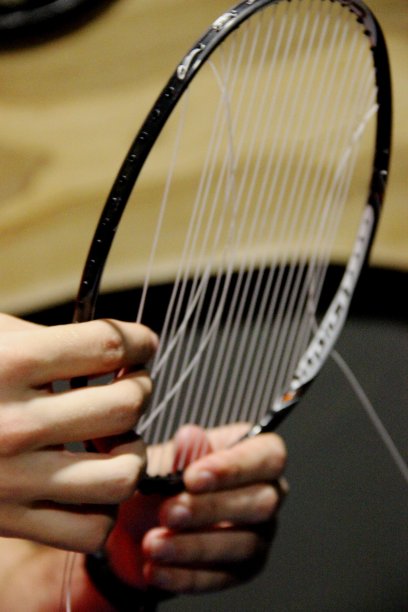 一个人在修理羽毛球拍。没有人。垂直调整羽毛球拍的弦张力图片下载
