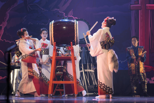 日式传统表演：演员身穿和服戴狐狸面具在舞台上演奏太鼓图片下载