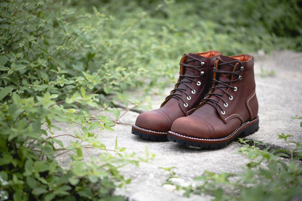 男士时尚的棕色皮靴在地板上。时尚广告靴子照片绿色背景。图片下载