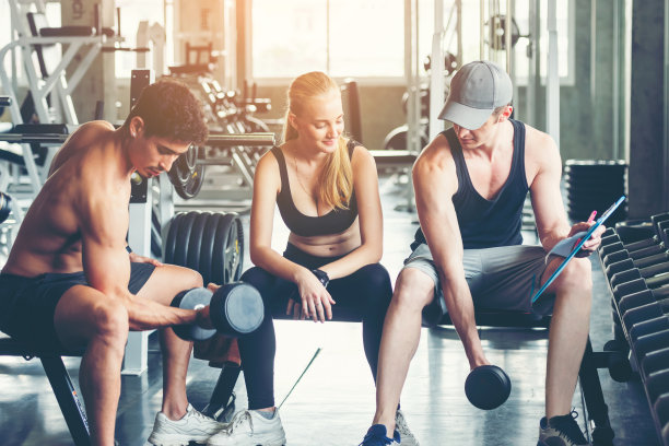 教练员与男女在健身房进行健身锻炼，以达到保健和瘦身的目的。健身教练和他的客户一起健身。饮食与健康运动的概念图片下载