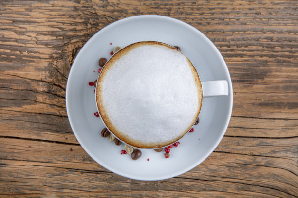 咖啡拿铁或卡布奇诺在杯子中与白巧克力和棕色巧克力在木背景。咖啡馆和酒吧，咖啡师艺术概念。图片下载