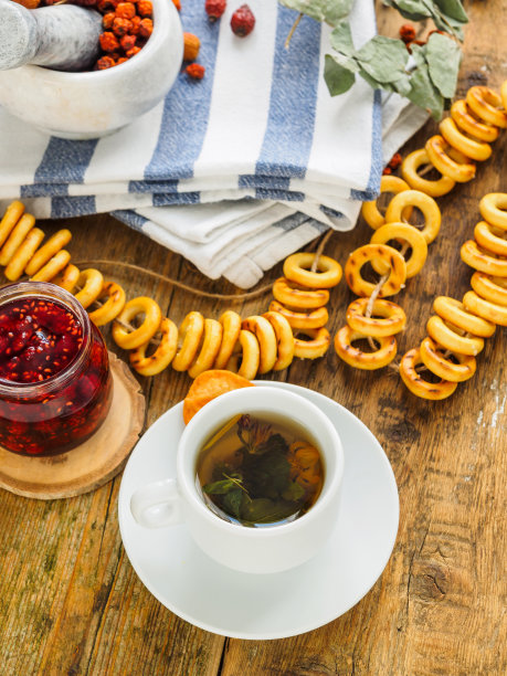 旧木桌上放着一杯茶和一条蓝色毛巾。香草和糖果图片下载