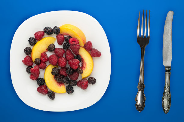 饮食,健康食品。黑莓、覆盆子、油桃放在盘子里的白色盘子里。素食食物的背景俯视图。图片下载