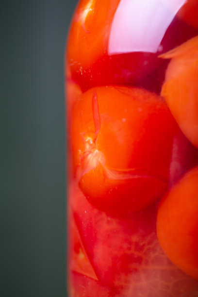 腌番茄在腌汁里，在一个玻璃罐子里放在木桌上。图片下载