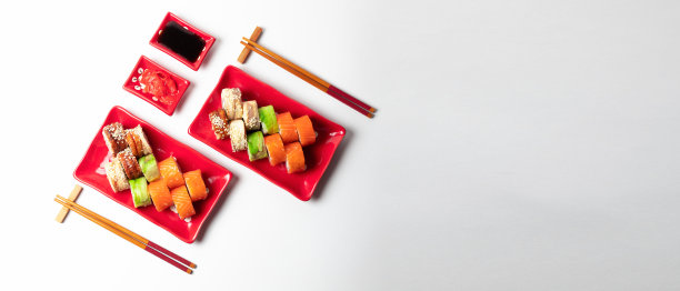 美味的寿司和卷在一个红色的盘子在白色的背景图片下载