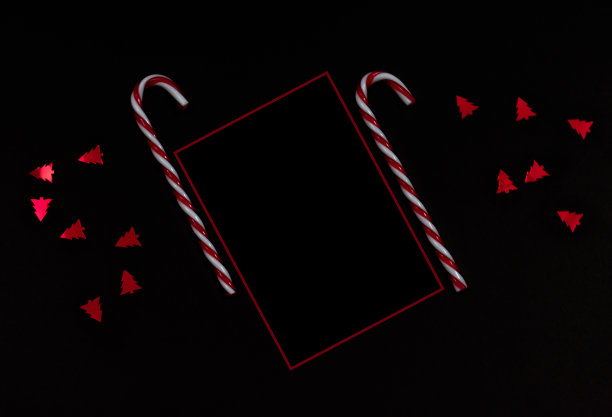 优雅的现代圣诞背景糖果手杖，红色框架和纸屑在黑色背景与复制空间图片下载