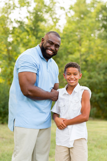 父亲和他的儿子在炫耀他们的二头肌。图片下载