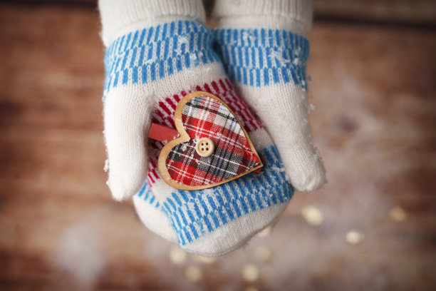 女孩的手在装饰的连指手套拿着木心图片下载