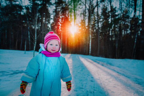 可爱的小女孩走在冬天的雪地里图片下载
