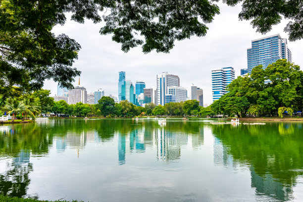 从市中心的隆皮尼公园可以看到曼谷的城市景观。全景照片的摩天大楼和未来的建筑从金属和玻璃。从朗皮尼公园的小湖看。新鲜的绿色植物。图片下载