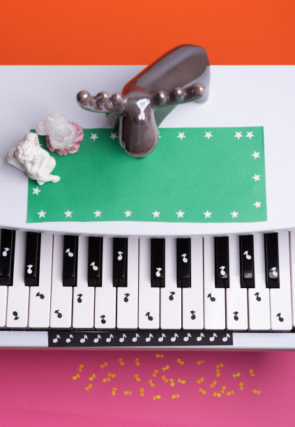 白色玩具钢琴和纸笔记。钢琴音乐的概念。从上面的观点图片下载