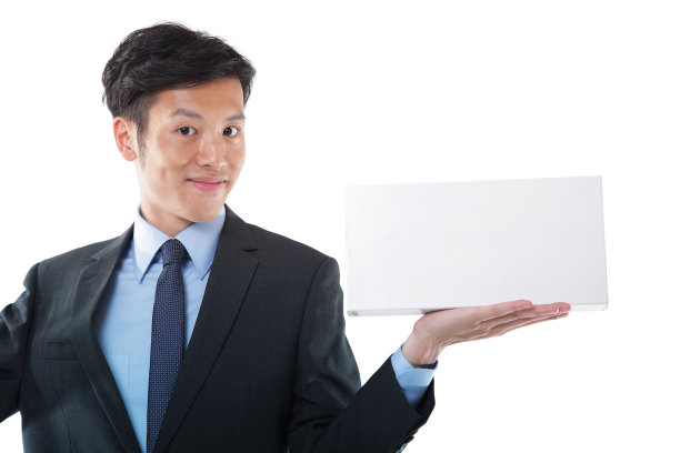 年轻的亚洲商人微笑着看着相机，用手势指着礼物或用一个空白的白盒子介绍某样东西图片下载