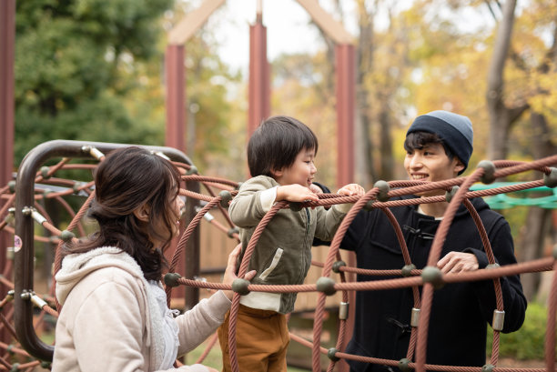 父亲扶着儿子玩户外游戏设备图片下载