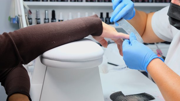 美甲师用指甲锉给客户锉指甲。修甲过程，指甲延伸图片下载