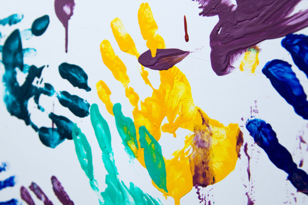 白色墙壁上的黄色掌纹，夹杂着其他的画笔和版画图片下载