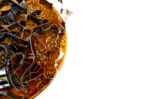 姜饼饼切。不锈钢模具烤圣诞饼干在棕色的陶瓷碗。白色与复制空间隔离图片下载