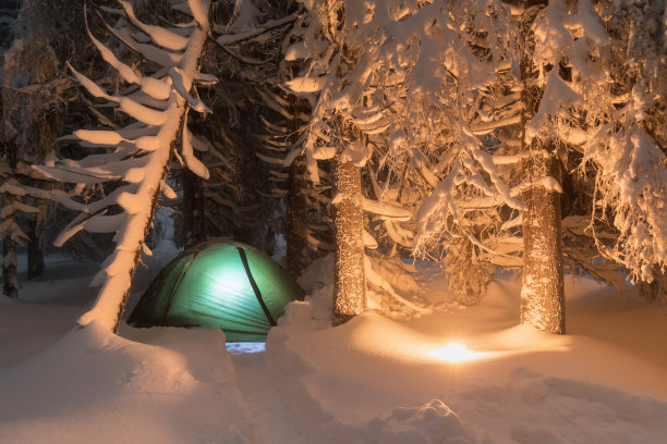 夜景拍摄，长时间曝光，睡在户外的雪地上。夜晚在山上露营，在夜空下的百万星级酒店，绿色照明帐篷在阿尔卑斯山口。圣诞佳节，恭贺新禧图片下载