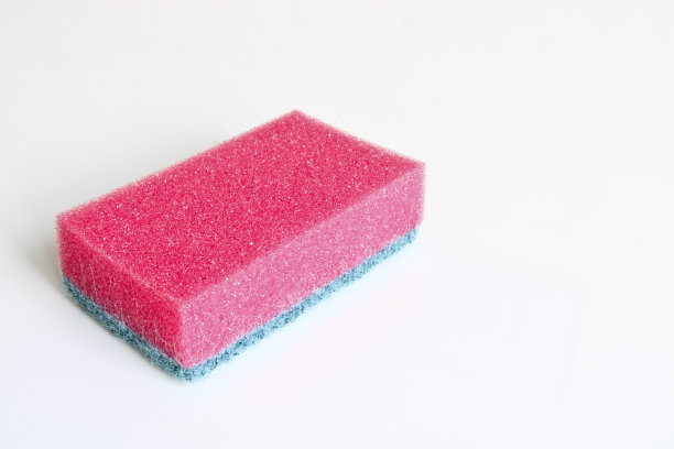 在较亮的背景上用厨房海绵做菜。特写镜头。图片下载