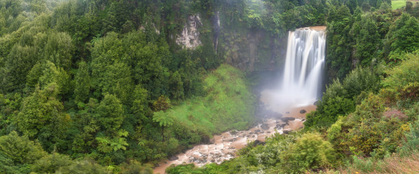全景照片景观/瀑布隐藏在热带丛林周围的自然游泳池与清澈的淡水在背景绿色的森林树和山，马拉科帕瀑布，新西兰图片下载