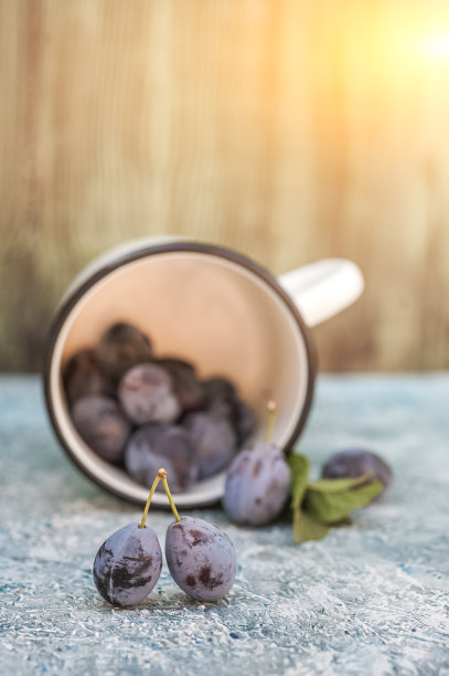 成熟多汁的李子上的蓝色背景特写。自制李子和拷贝空间。图片下载