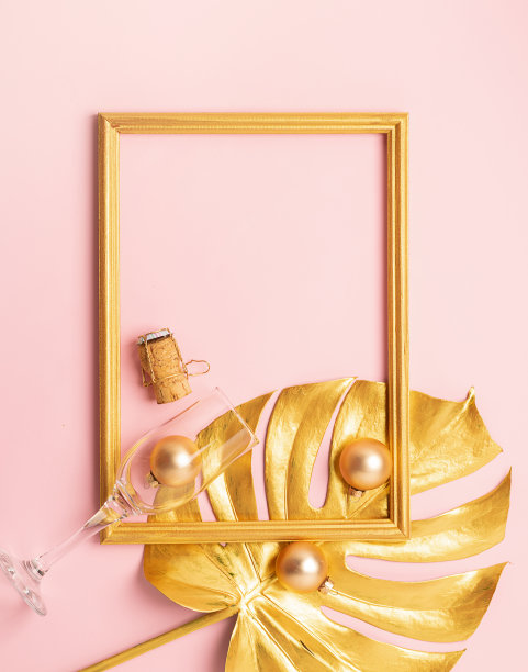 圣诞玩具空玻璃片热带植物蛇纹石软木香槟金色在粉红色的背景。图片下载