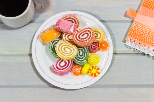 灰色的木桌上放着水果果冻和一杯咖啡。明亮的颜色。咖啡休息。图片下载