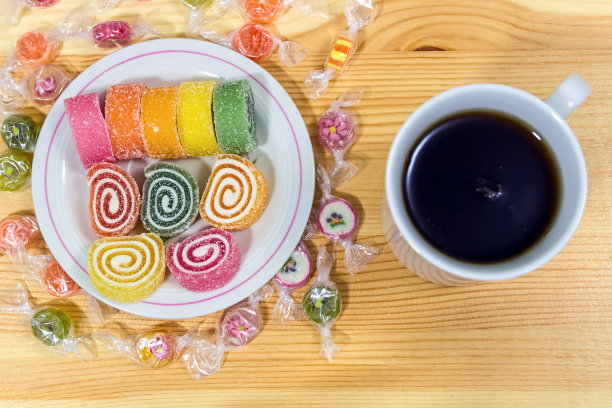 灰色的木桌上放着水果果冻和一杯咖啡。明亮的颜色。咖啡休息。图片下载