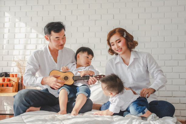 一个家庭的父亲，母亲，儿子穿着白色衬衫拿着相机，在白色房间的白色房间摆着照片。保持对儿子童年生活方式的美好回忆图片下载