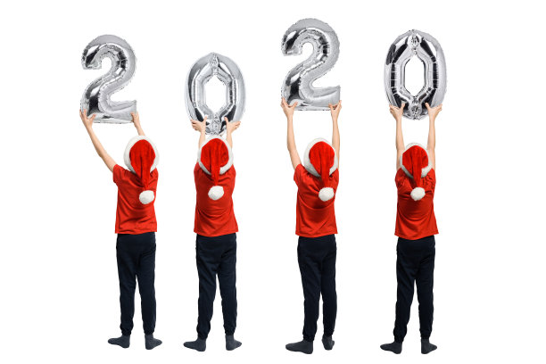 闪亮气球的2020号。戴着红帽子的男孩手里拿着数字。白色背景图片下载