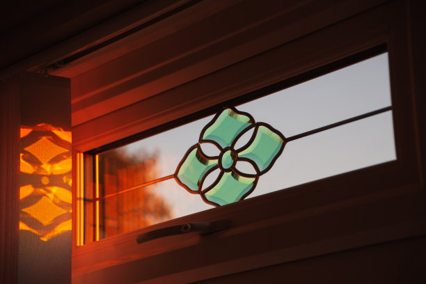 翠绿色斜面顶灯双层玻璃窗设计，捕捉到夕阳的光芒，并反射到垂直百叶窗上。图片下载