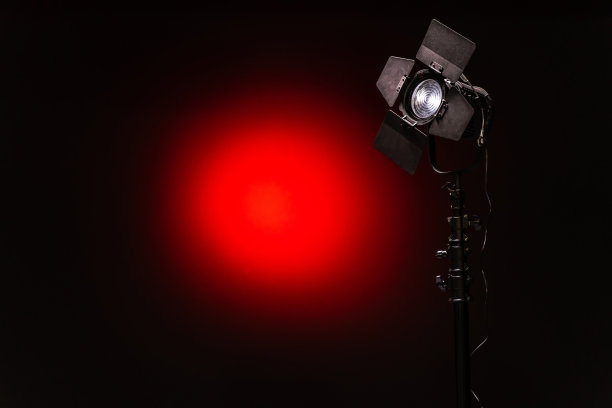 LED聚光灯与菲涅尔镜头黑色和红色背景特写图片下载