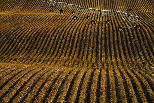 肥沃犁沟农田上的支点灌溉输水设备图片下载