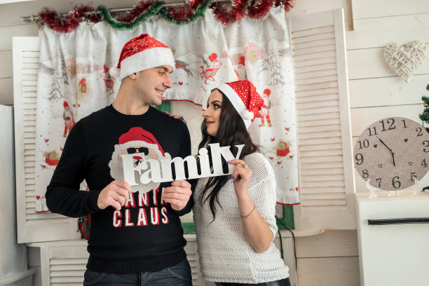 一对夫妇举着“家庭”这个词，看着对方图片下载