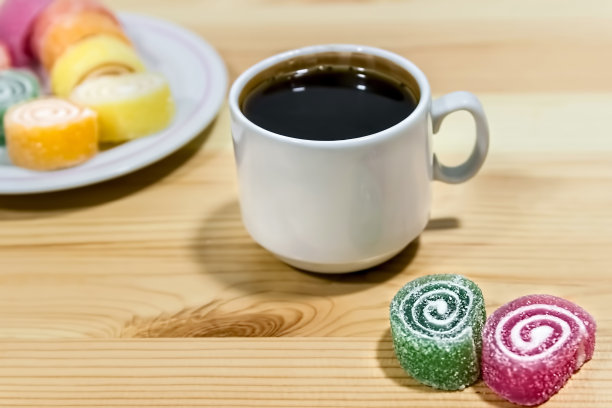 灰色的木桌上放着水果果冻和一杯咖啡。明亮的颜色。咖啡休息。图片下载