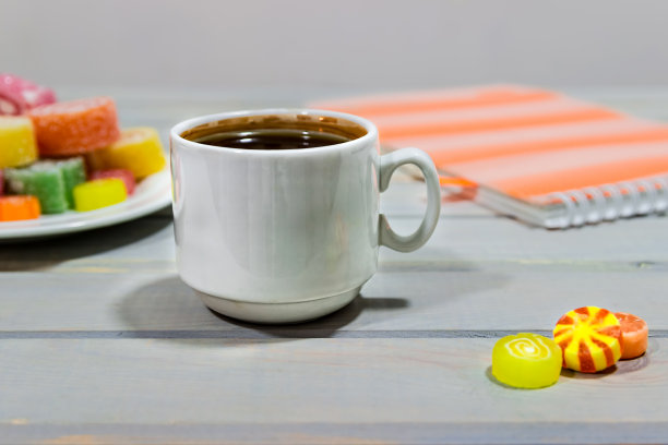 灰色的木桌上放着水果果冻和一杯咖啡。明亮的颜色。咖啡休息。图片下载