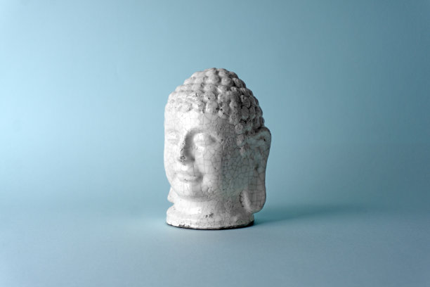 蓝色背景上的陶瓷佛像头。最小的概念，复制空间图片下载