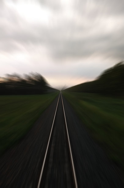 铁路在日落背景的运动。带有运动模糊效果的火车站映衬着绚丽的蓝天，工业概念背景。铁路旅游，铁路旅游。模糊的铁路。图片下载