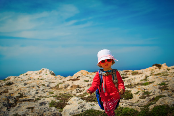 可爱的小女孩背着背包在海边的山中旅行图片下载
