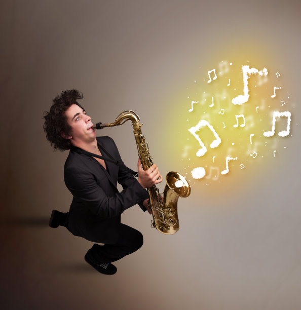 英俊的音乐家用萨克斯吹着音符图片下载