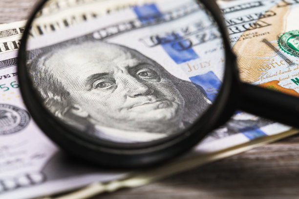 核实货币的真实性。本杰明·富兰克林通过放大镜看镜框。检查美元图片下载