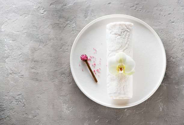 水疗兰花按摩香薰身体护理。海盐和毛巾，俯视图，平铺在混凝土背景上图片下载