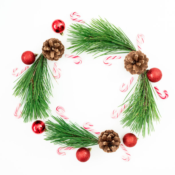 圣诞快乐组成的松树枝和红球装饰与糖果手杖在白色的背景。平躺，俯视图图片下载