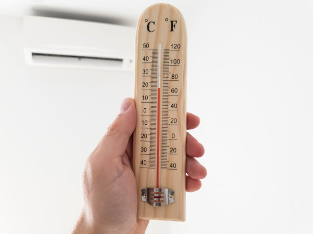 温度计和温度测量与现代空调机组在客厅内的白色墙壁上。图片下载