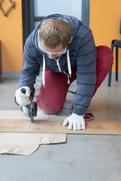 维修和装饰。一个男人用研磨机切割瓷砖。图片下载