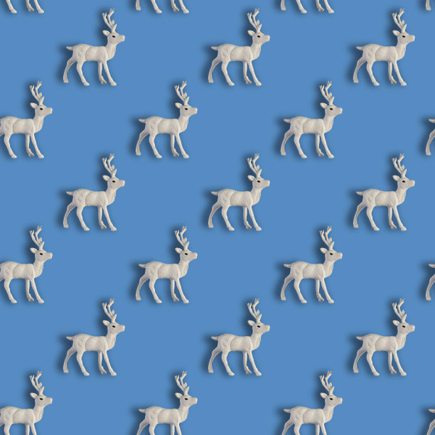 无缝圣诞图案与圣诞白鹿在蓝色的背景。图片下载