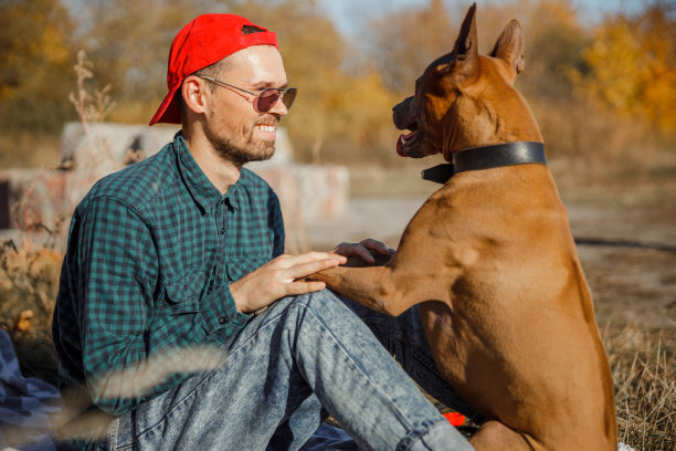微笑的年轻人花时间与他的狗库存照片图片下载
