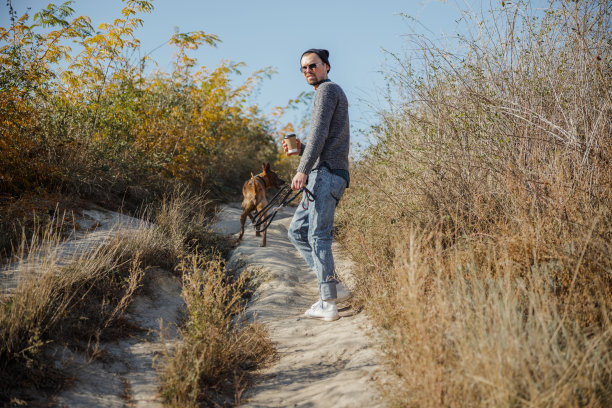 男人与咖啡和皮带他的狗库存照片图片下载