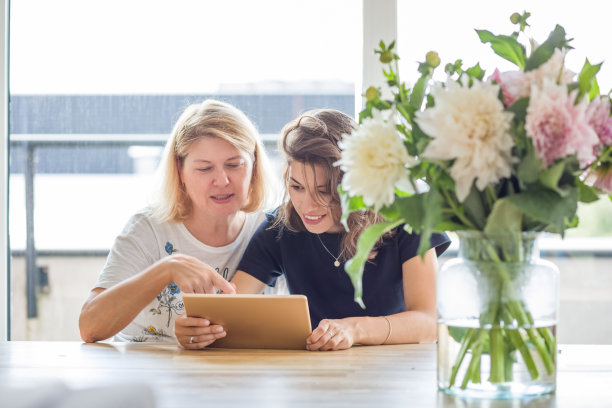 快乐的母亲和女儿享受数码平板电脑。图片下载