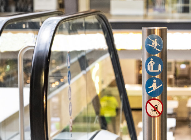 在商场的自动扶梯上有安全警示和使用信息标志。图片下载