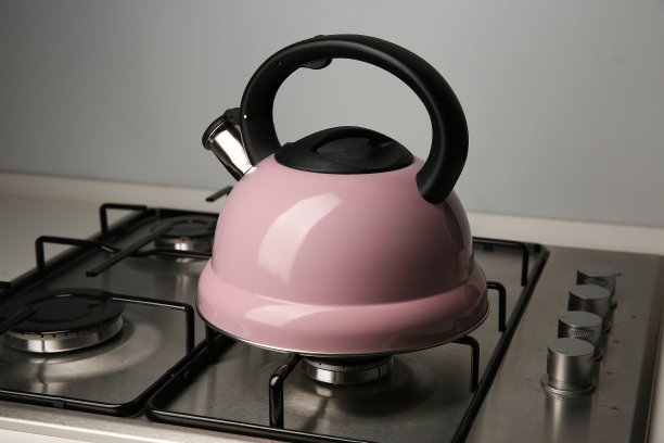 厨房煤气炉上的粉红色水壶图片下载